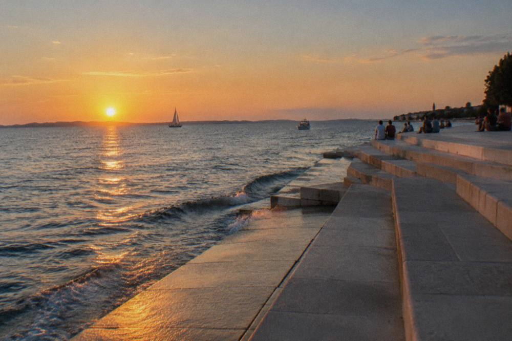 Distant visitors on the broad stone steps beside the Sea Organ as the sun lowers.