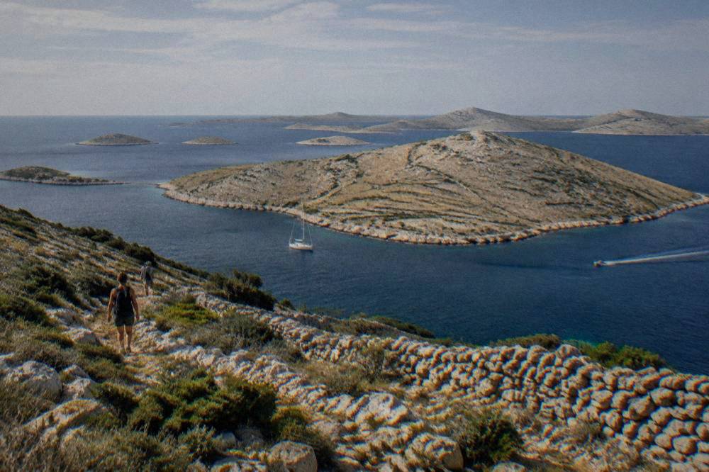 A cluster of bare stone Kornati islands with dry-stone walls under a clear sky.