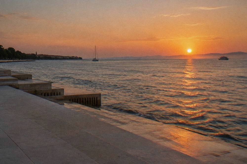 The sun setting over the Adriatic seen from the pale stone steps of the Sea Organ.