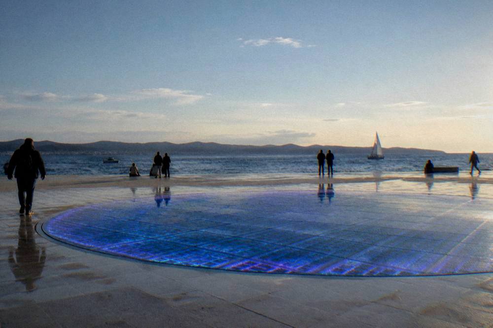 The glass solar circle on Zadar's waterfront glowing blue and violet at night.