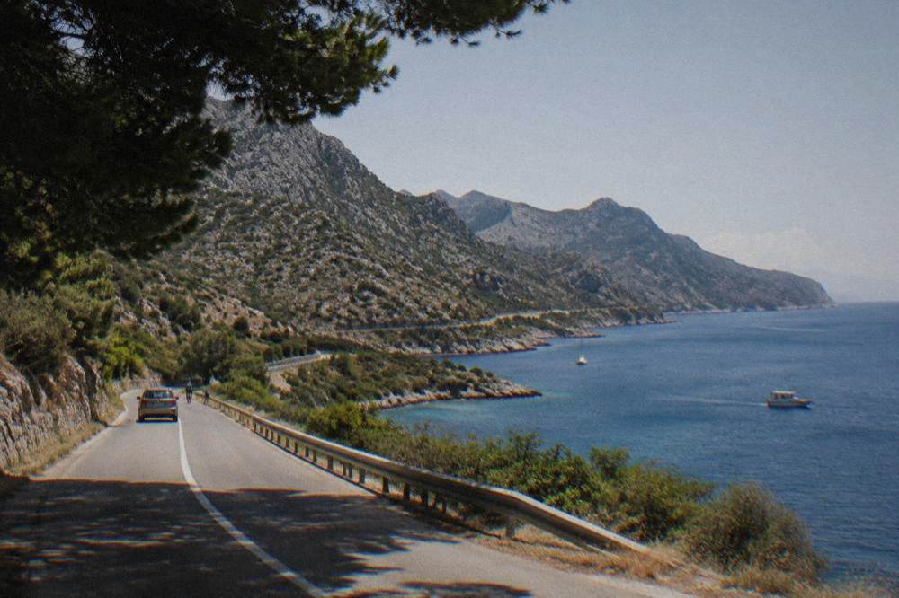 A coastal road winding between karst hills and the blue Adriatic.