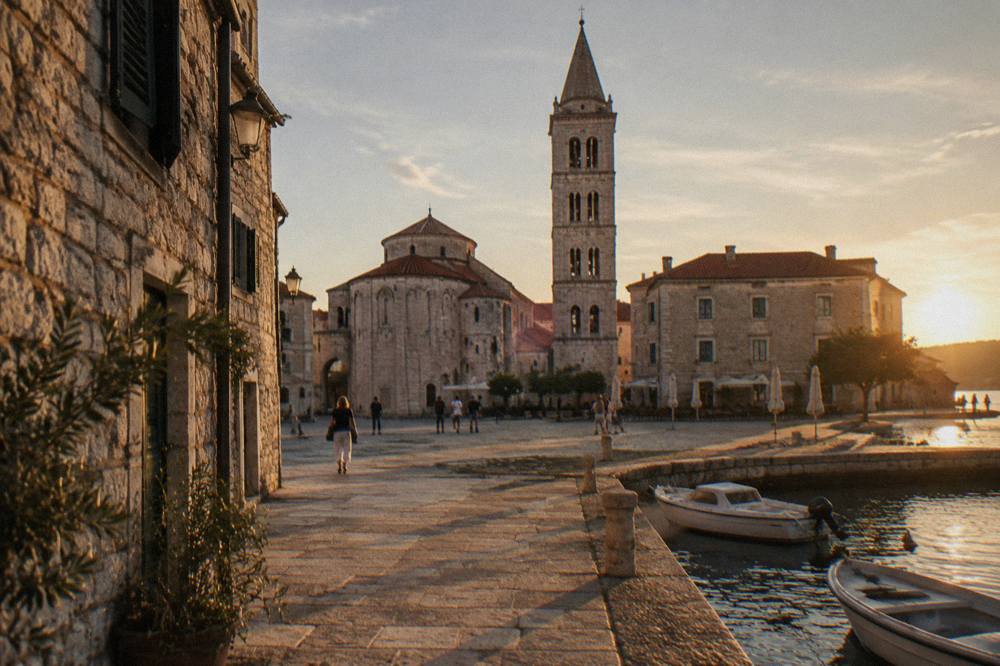 Stone buildings of Zadar old town around a small square with terracotta roofs and a bell tower.