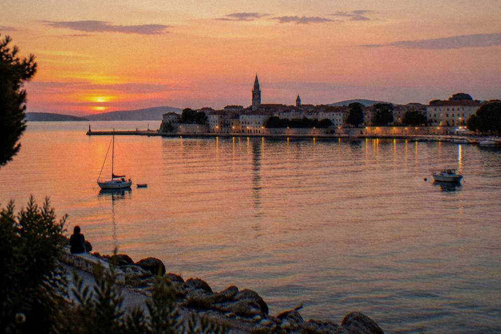 Evening view of the Zadar peninsula from across the bay as lights begin to show.