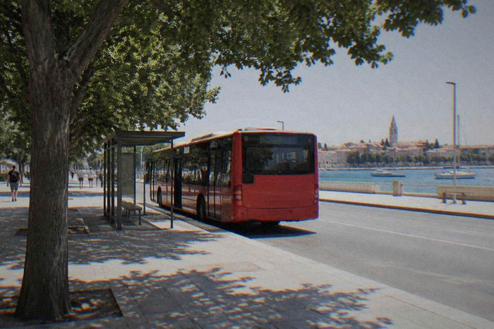 A city bus pausing at a stop shelter in central Zadar with trees and pale paving.
