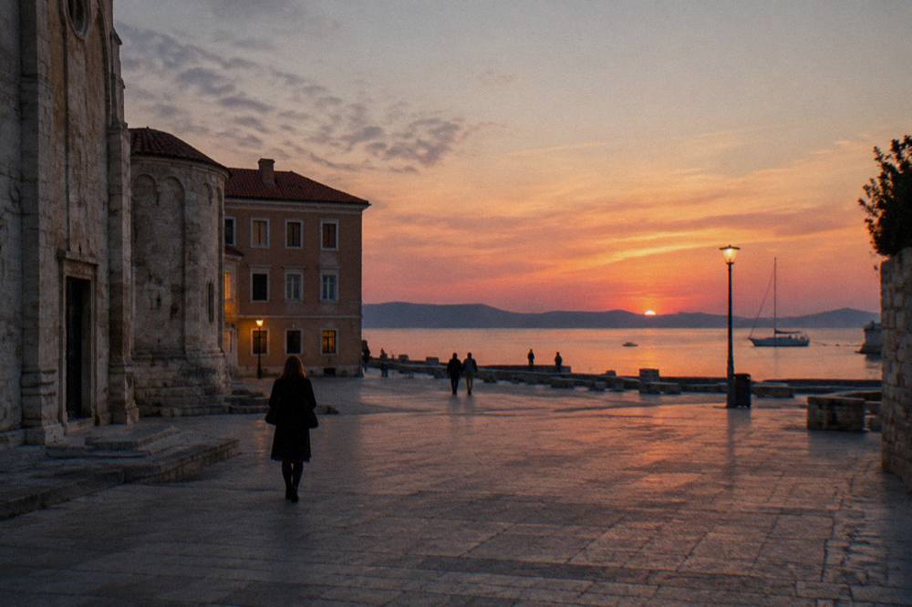 A stone square lit softly at dusk with a few distant people.
