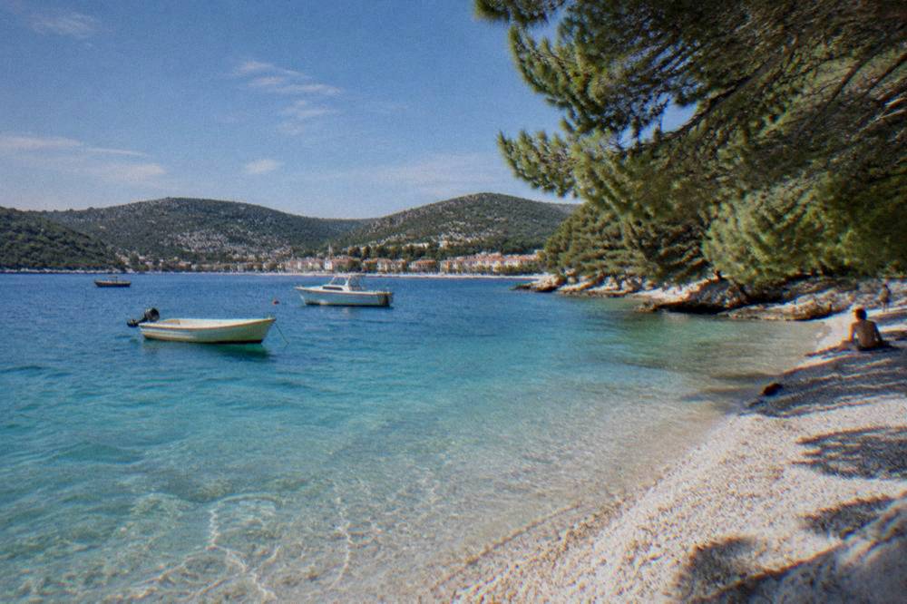 Turquoise shallow water and a white pebble beach on a Dalmatian island.