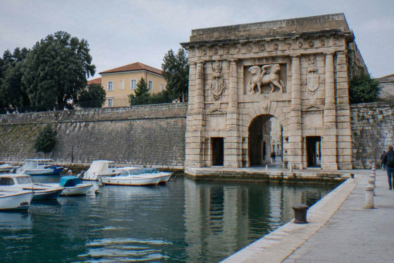 The Land Gate arch and old stone walls beside the harbour in Zadar.