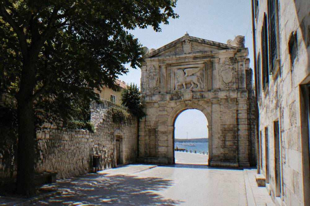 The carved Renaissance Sea Gate arch in a quiet street of Zadar.