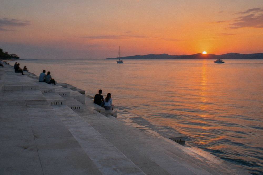 The marble steps of the Sea Organ descending into the calm Adriatic at sunset in Zadar.
