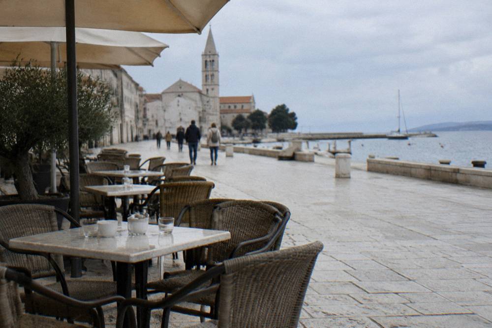 Cafe terrace with empty tables on the limestone Kalelarga street in Zadar.