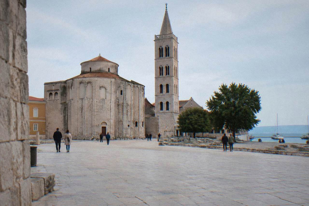Limestone square in Zadar old town with a bell tower and the round St Donatus church.