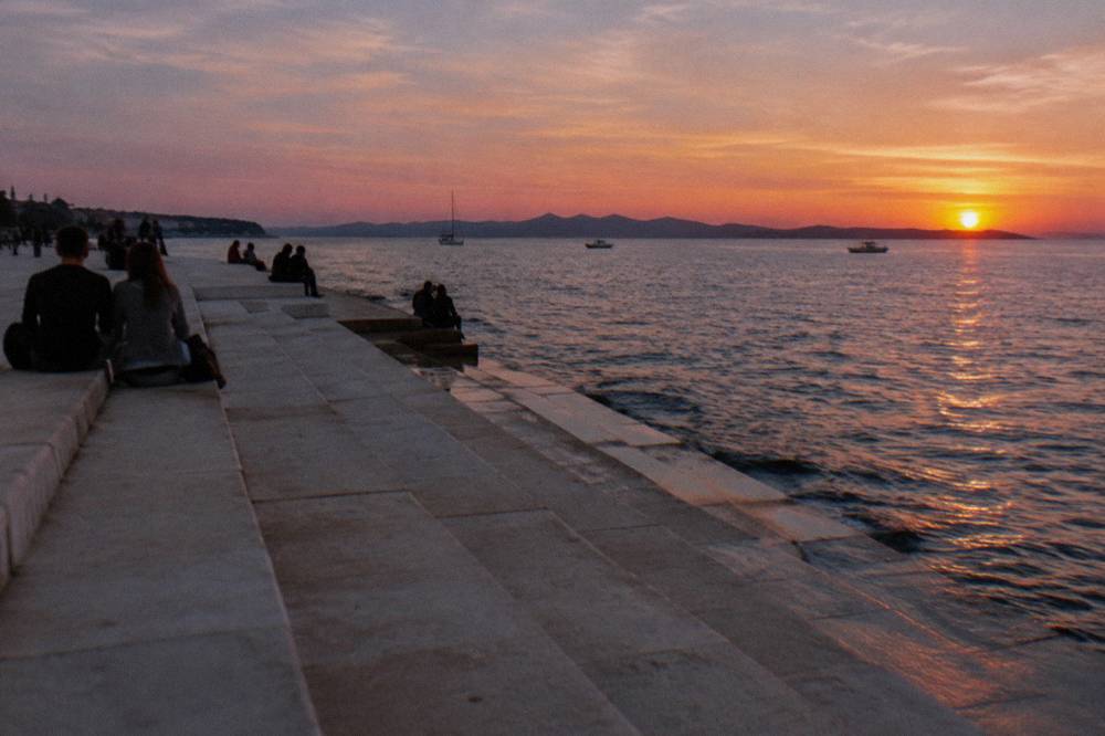 Twilight over the Sea Organ steps and calm water in Zadar.