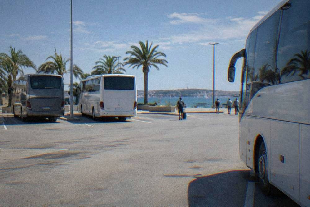 Coaches parked at bays at Zadar bus station on a sunny day.