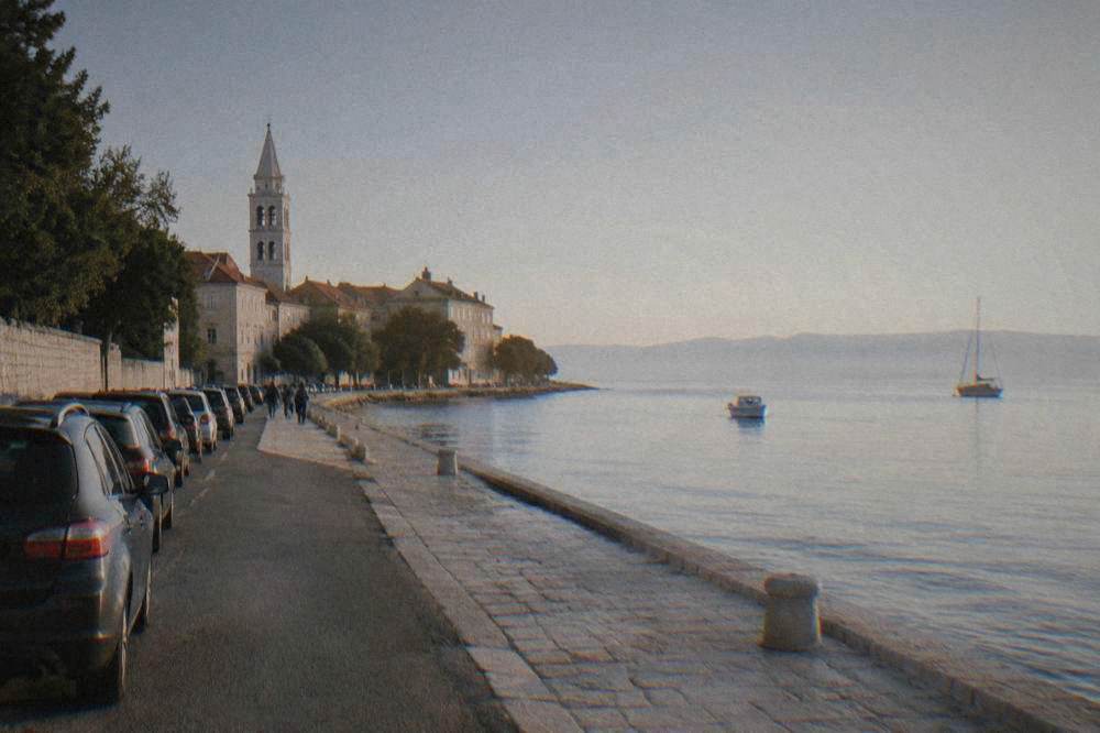 Parked cars beside the stone-edged sea promenade along the Zadar peninsula.