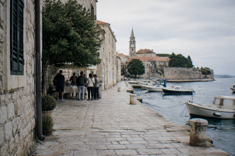 Distant walkers stopping on a limestone lane in Zadar old town.