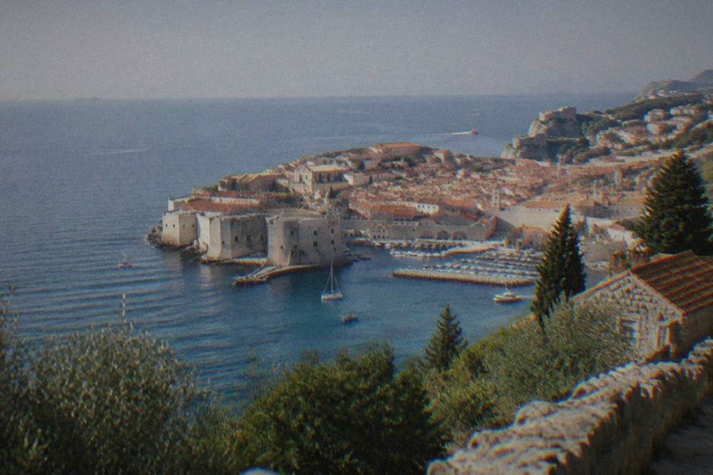 Dubrovnik old town walls and terracotta roofs seen from a hillside viewpoint above the sea.