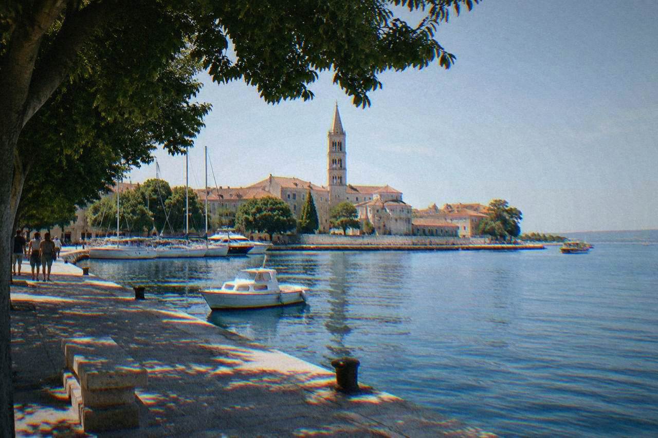 Zadar peninsula and harbour in clear morning light with a bell tower and limestone quay.