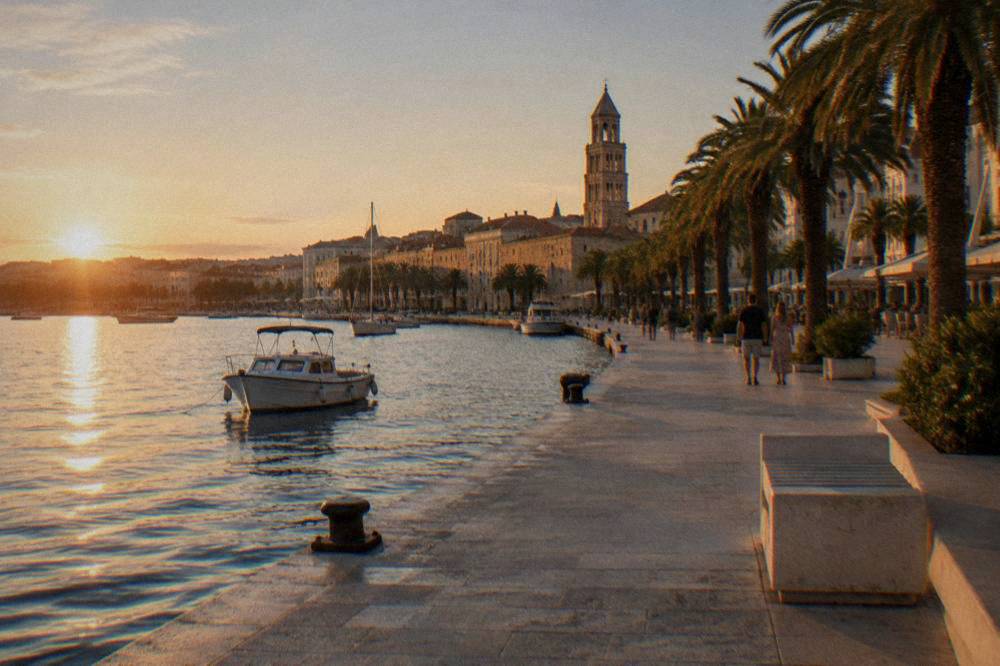 Split Riva promenade in soft September light with palms and stone buildings.