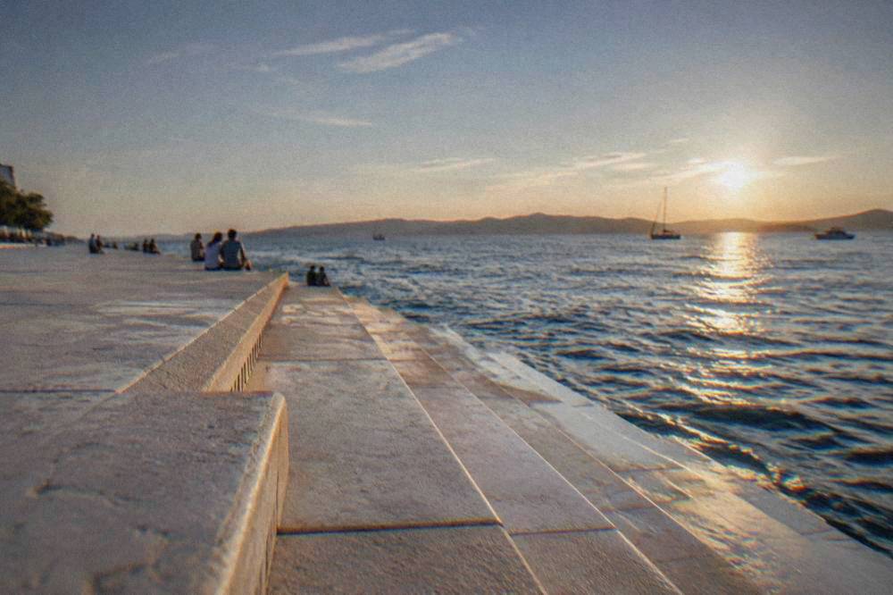 The Sea Organ marble steps and calm sea at golden hour in Zadar.