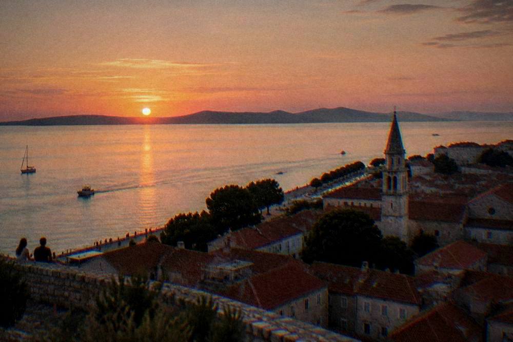 Sunset over the Zadar channel with old town roofs and coast.
