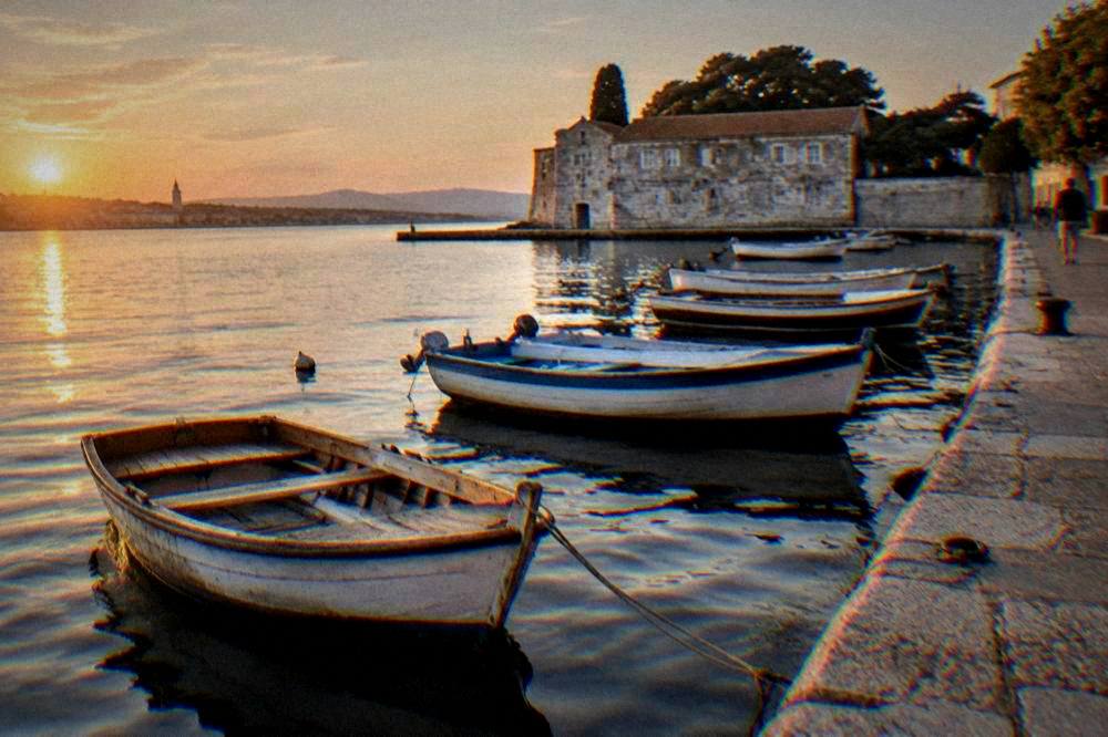 Wooden rowboats and a stone quay at Foša harbour in Zadar, calm and uncrowded.