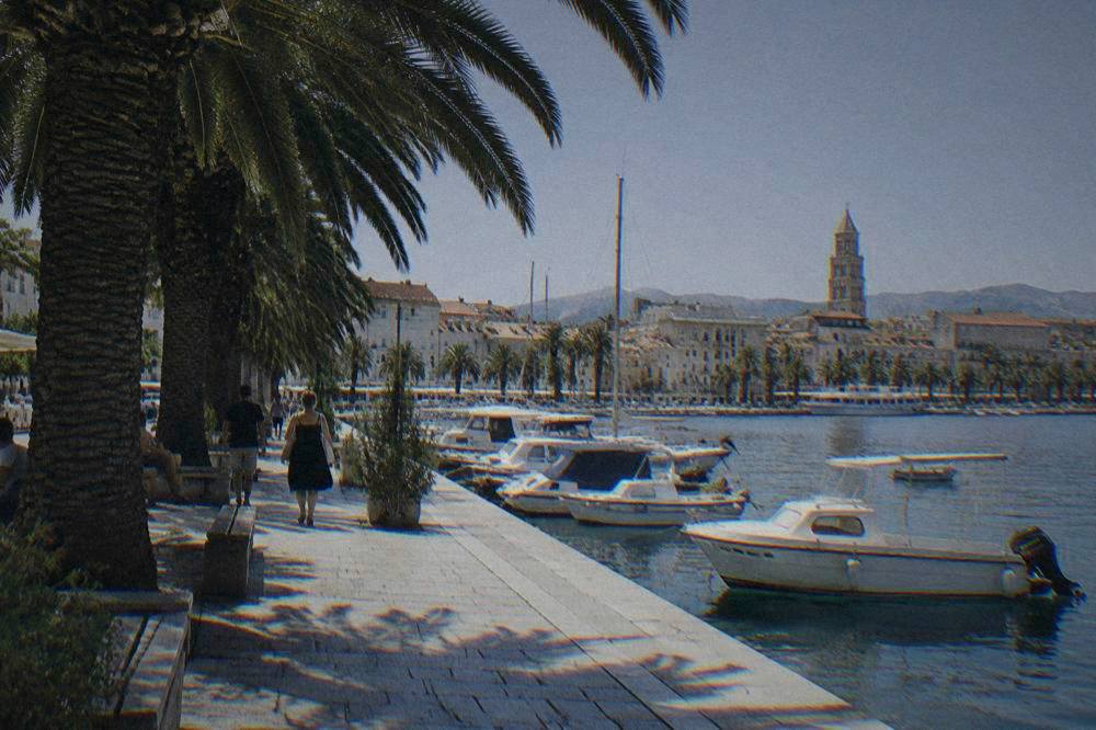 Split Riva waterfront with palms and a stone promenade beside the harbour.