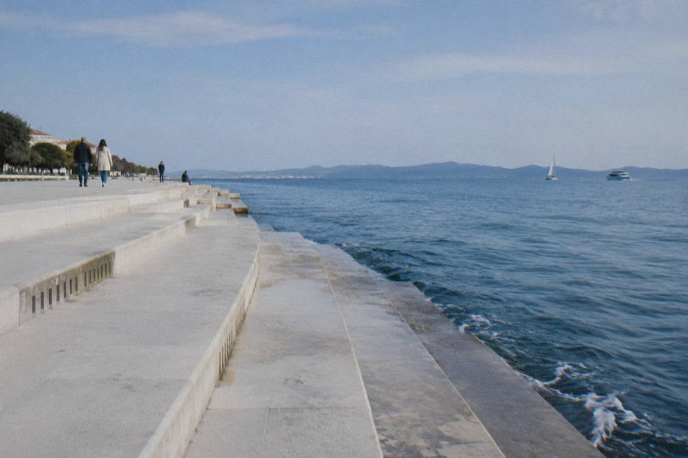 The Sea Organ steps and calm blue sea under a clear sky in Zadar.