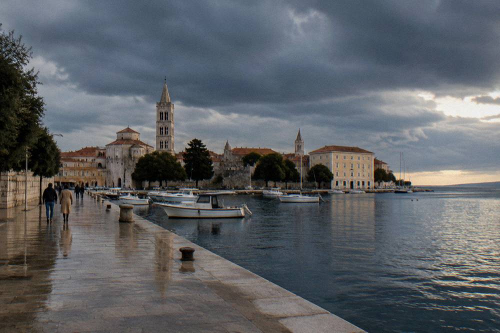 Rain clouds over Zadar old town roofs with damp shining limestone.