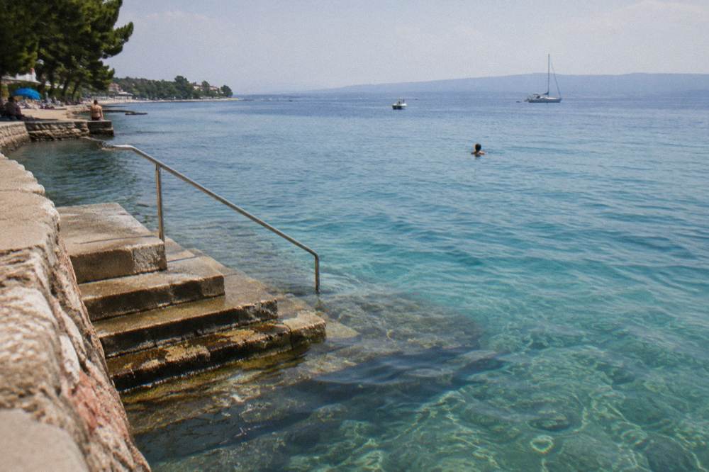 Clear turquoise water and steps into the sea at Kolovare Beach in Zadar.