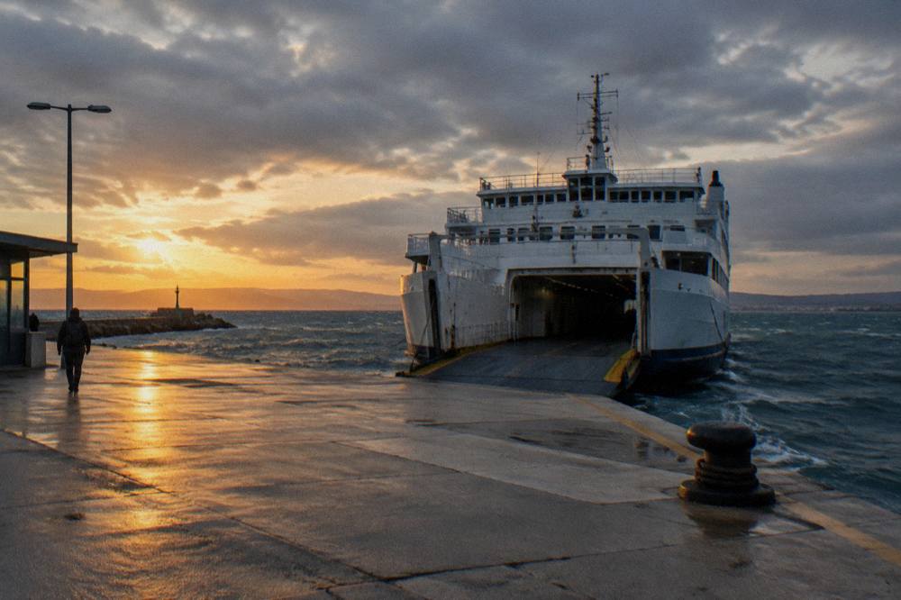 A ferry waiting at the Gaženica quay under an overcast windy sky.