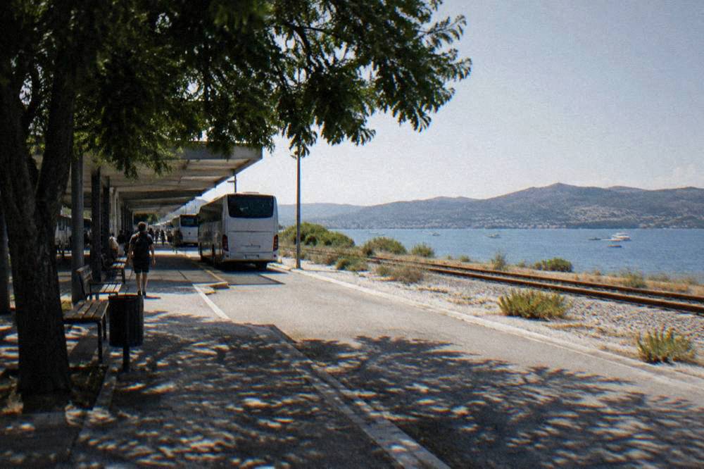 A quiet platform edge with gravel and scrub near Zadar bus station.