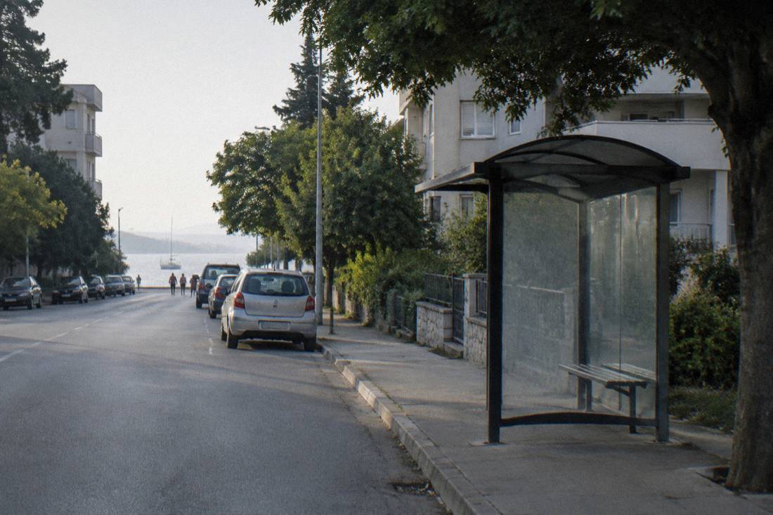 A quiet residential street of low apartment buildings and mature trees in Arbanasi, Zadar