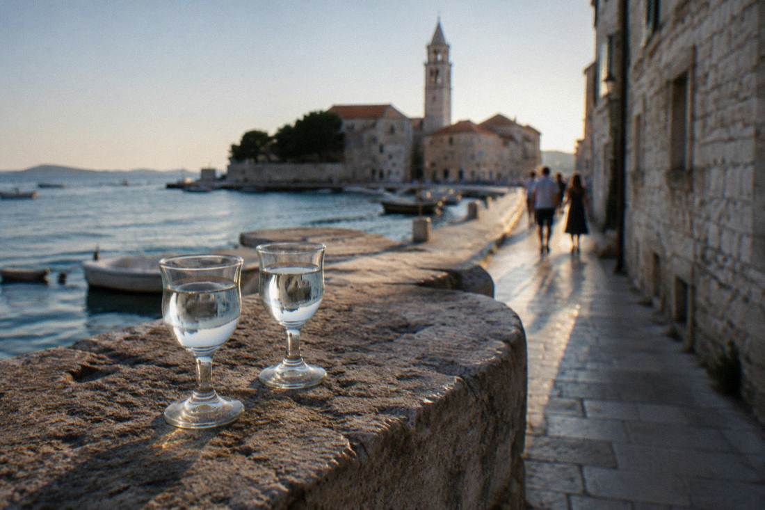 Small glasses of clear cherry liqueur on a stone ledge
