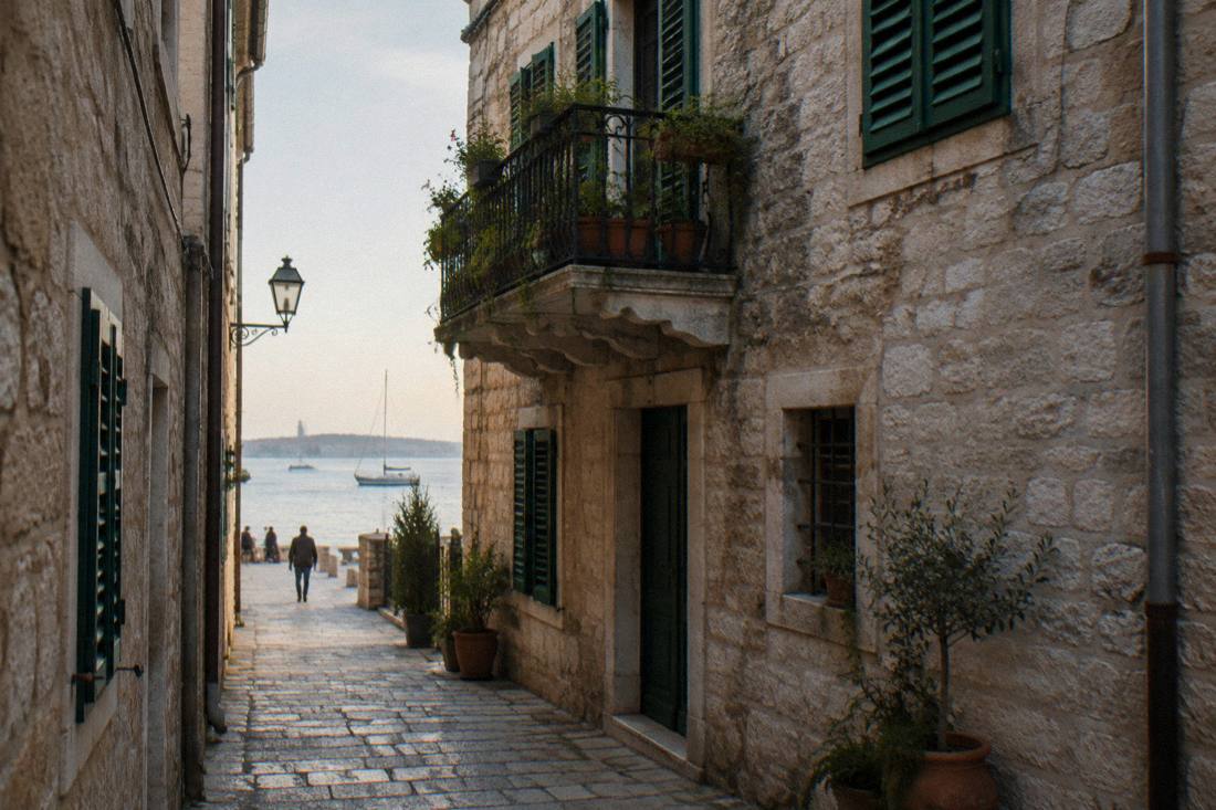 A stone townhouse with green shutters on a narrow lane in Zadar old town