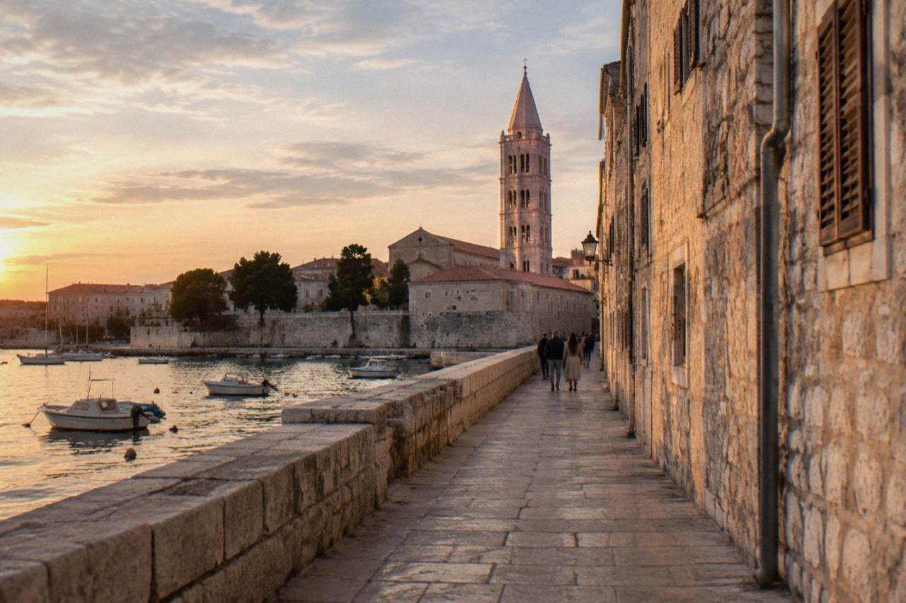 Old Town lane at golden hour with a bell tower rising ahead