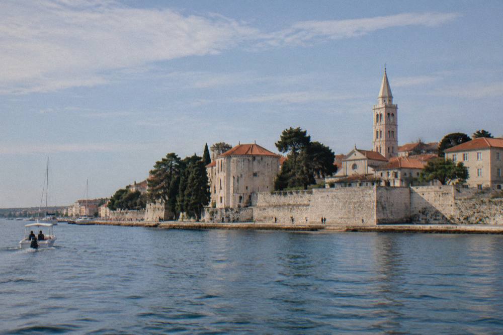 Zadar peninsula seen from the water with walls, roofs and a tower