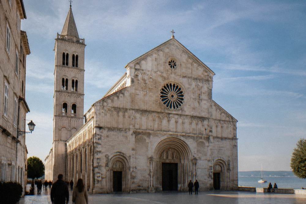 Romanesque cathedral facade with a rose window and bell tower