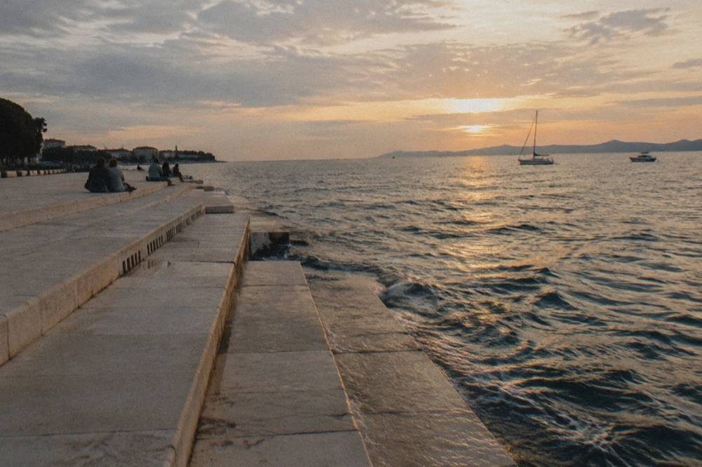 Marble steps down to the sea at golden hour on a clear day