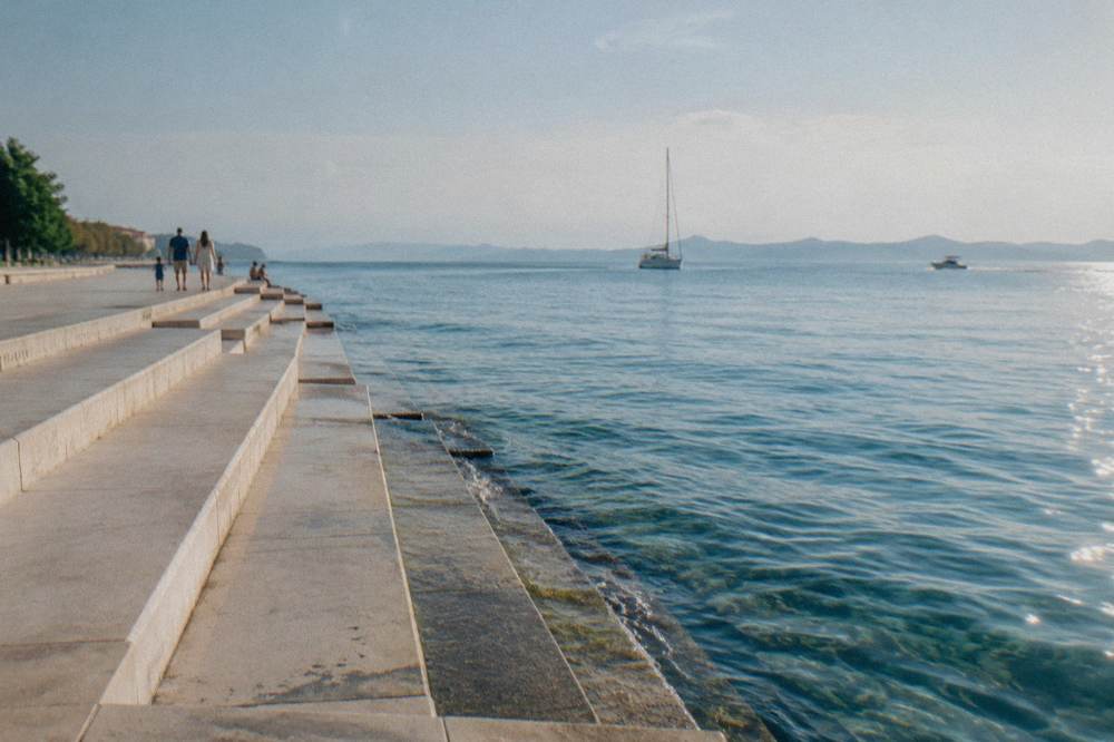 Marble steps descending to the calm sea in afternoon sun