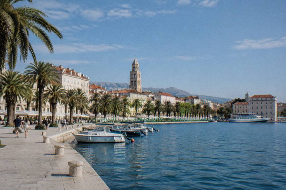 Split Riva waterfront with palms, pale buildings and a bell tower