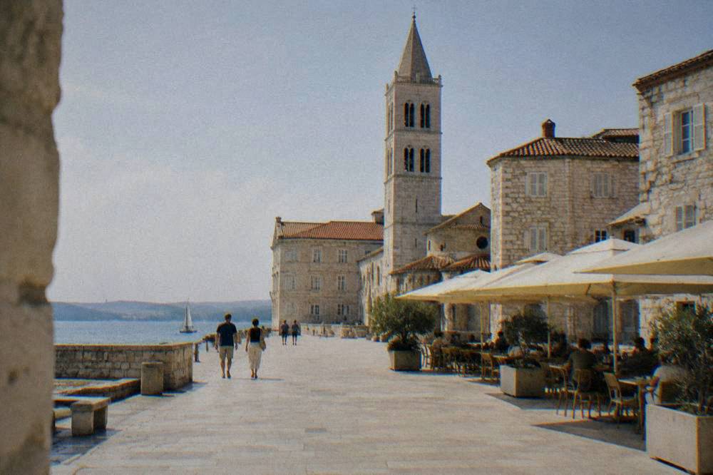 Compact Old Town square with a bell tower and cafe parasols