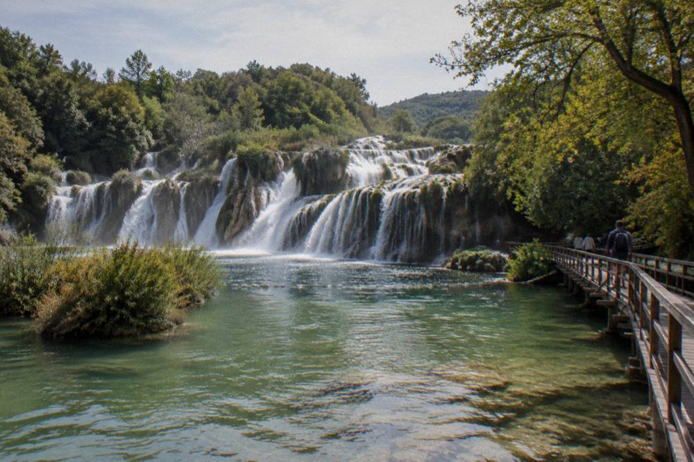 Travertine falls and green pool with a boardwalk in Krka park