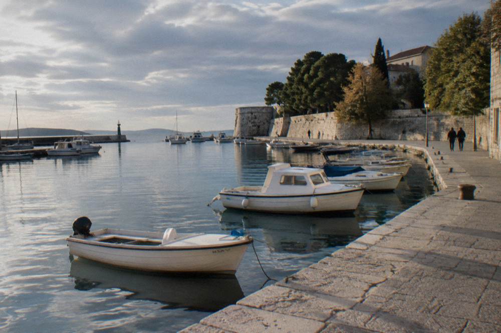 Small boats moored in the harbour under a cloudy sky