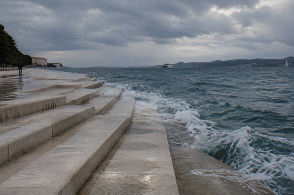 Marble steps by the sea under a dramatic cloudy sky